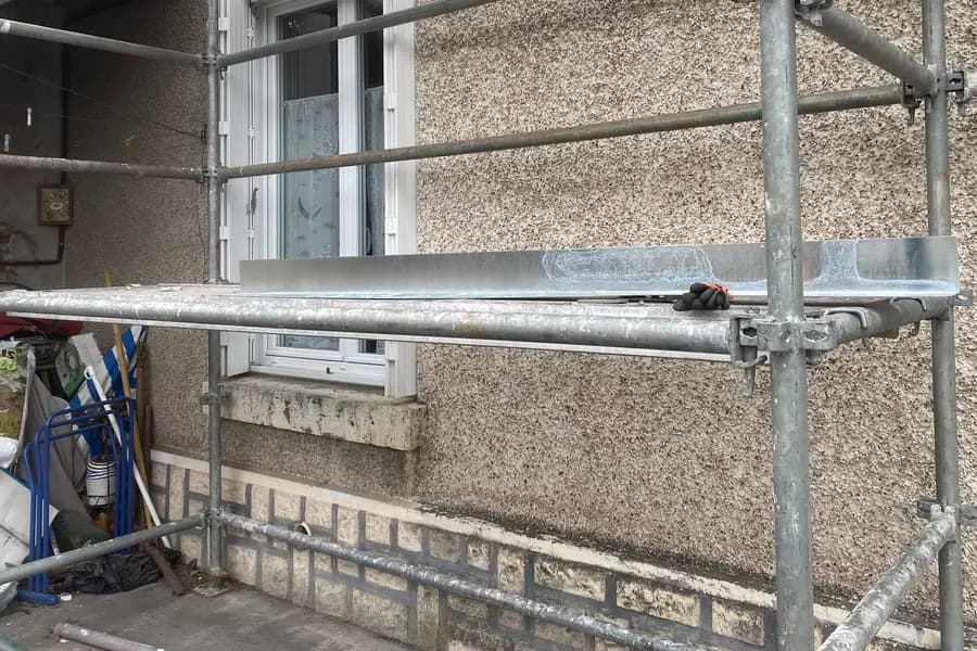 Longueur de zinc façonnée à l’atelier, posée sur le plancher d’échafaudage, prête à être mise en place