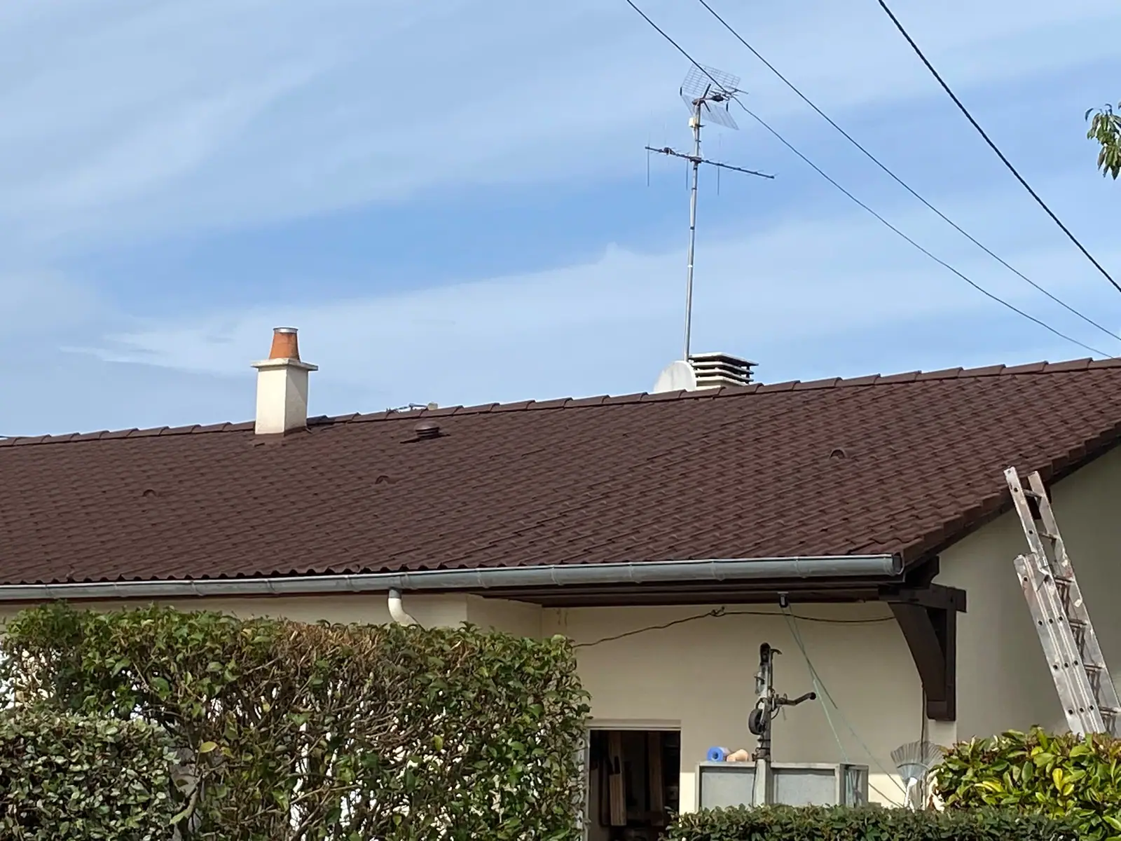 Toiture en tuiles régulière avec deux souches de cheminée et son évacuation d’eaux pluviales — Dacquin Couverture